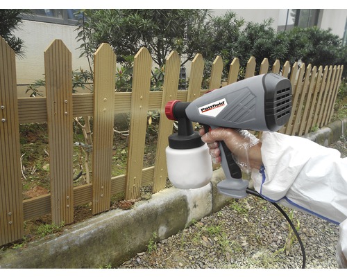 Farbsprühsystem im Einsatz beim Streichen eines Holzzauns