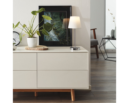 Salon moderne avec commode, lampe de table et objets de décoration