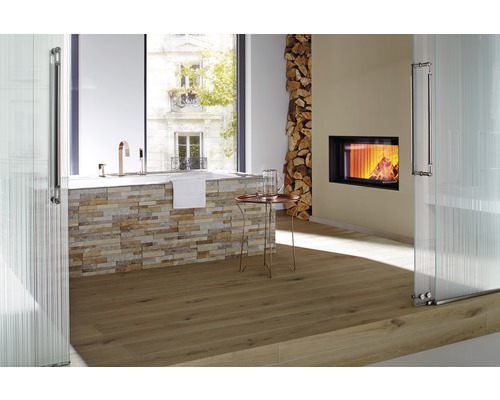 Badezimmer mit Badewanne, Kamin, Holzstapel und Holzboden