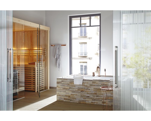 Badezimmer mit Sauna, Badewanne und Fenster mit Blick auf ein Gebäude