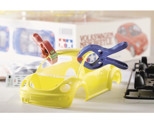 Maquette de voiture Volkswagen New Beetle jaune en construction avec outils