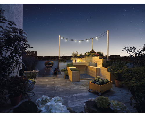 Jardin de toit avec mobilier en bois, barbecue et éclairage sous le ciel étoilé