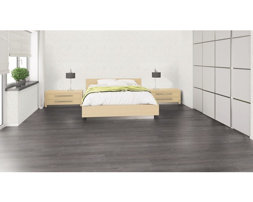 Schlafzimmer mit Bett, Nachttischen, Lampen, Schrank und grauem Holzboden