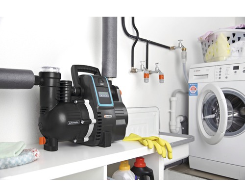 Surpresseur domestique Gardena dans la buanderie, à côté du lave-linge et du lavabo