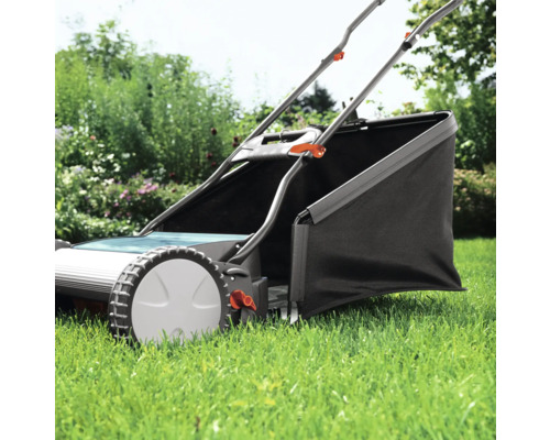 Handrasenmäher mit Grasfangkorb im Garten