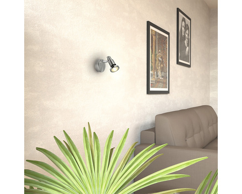 Wohnzimmer mit Wandleuchte, Couch und Bildern an der Wand