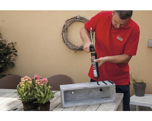 "Un artisan applique du mastic sur un coffre en béton 