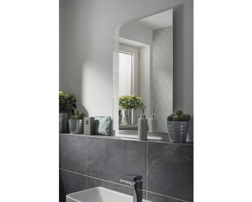 Badezimmer mit Spiegel, Waschbecken und Dekorationsartikeln