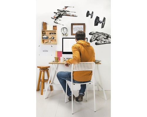 Aménagement d''un espace de travail avec bureau, chaise et décoration murale sur le thème de Star Wars.