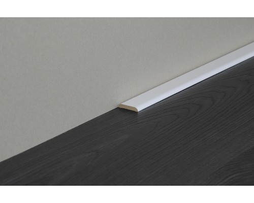 Weiße Fußleiste auf dunklem Holzboden an einer Wand