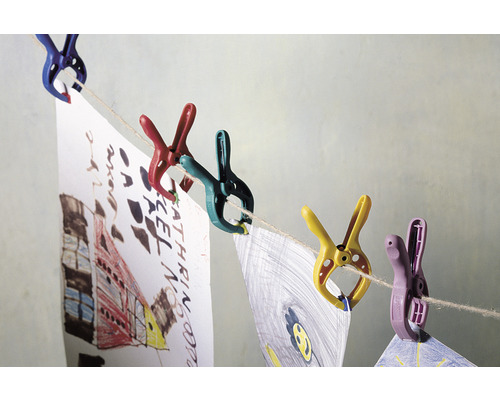 Des pinces à linge colorées maintiennent des dessins d''enfants sur une corde à linge