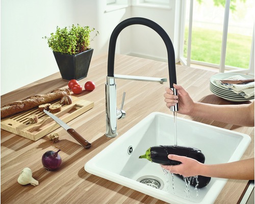 Küchenspüle mit ausziehbarer Armatur und Gemüse im Waschbecken