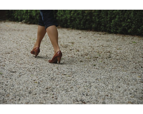 Femme marchant sur un chemin de gravier avec des chaussures