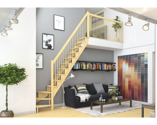 Espace de vie avec escalier en bois menant à la mezzanine, canapé et bibliothèque.