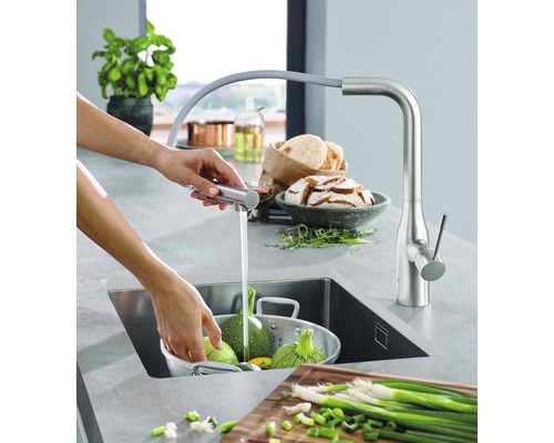 Küchenszene mit Armatur, Spüle und Gemüse