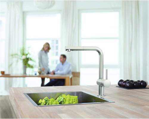 Küchenszene mit Spüle, Armatur und Gemüse auf einer Arbeitsplatte