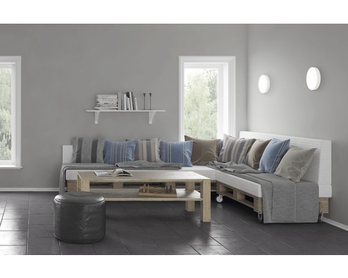 Wohnzimmer mit Palettenmöbeln und dekorativen Kissen.