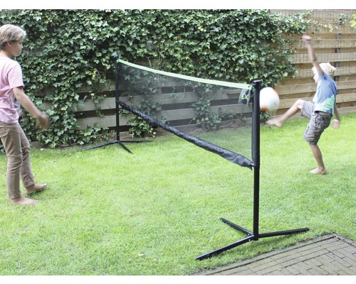 Scène de loisirs avec deux enfants jouant dans le jardin avec un filet de jeu multifonctionnel