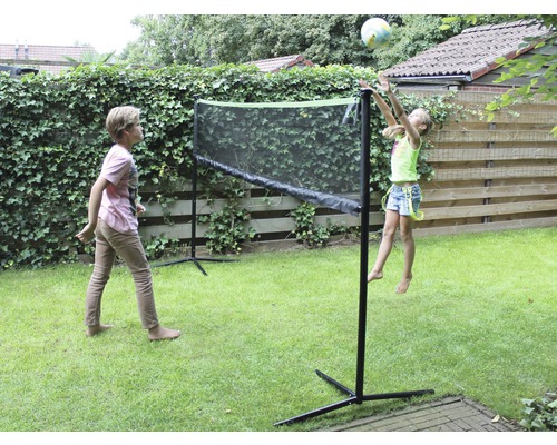 Deux enfants jouent avec un filet dans le jardin.