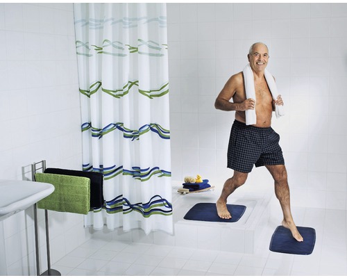 Salle de bain lumineuse avec rideau de douche, tapis de bain et serviettes