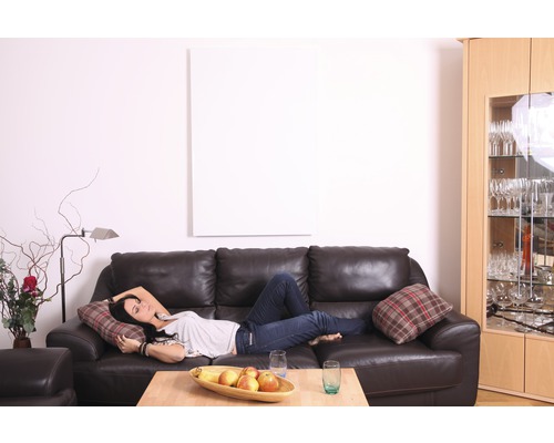 Wohnzimmer mit braunem Ledersofa, Frau, Holztisch mit Obstschale und Glasschrank