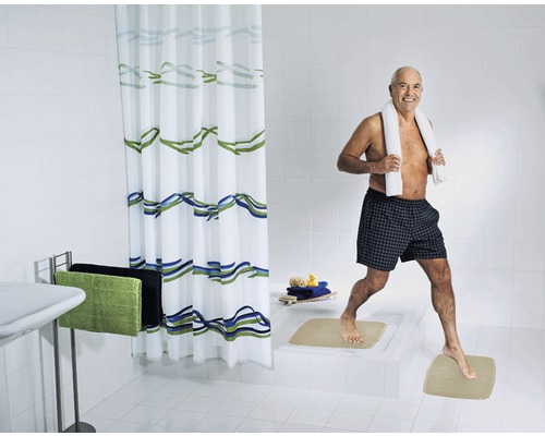 Salle de bain lumineuse avec rideau de douche, serviettes et tapis de bain
