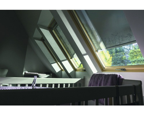 Une chambre d''enfant avec des fenêtres de toit et un lit de bébé.