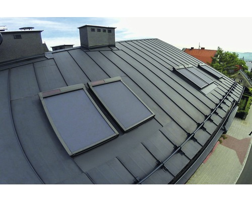 Toit métallique avec fenêtres de toit et système de drainage de toit.