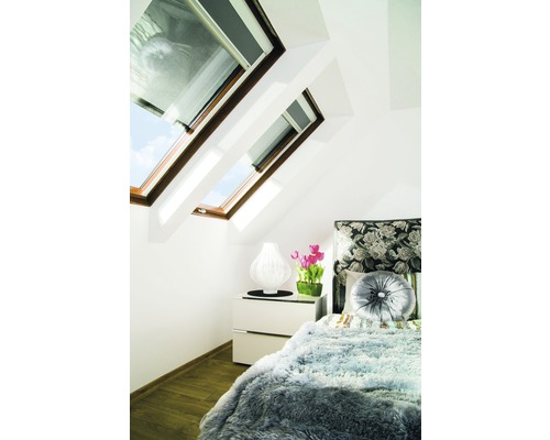 Chambre avec fenêtres de toit, table de chevet et lit