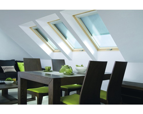 Séjour avec fenêtres de toit, table à manger et sièges dans un grenier lumineux