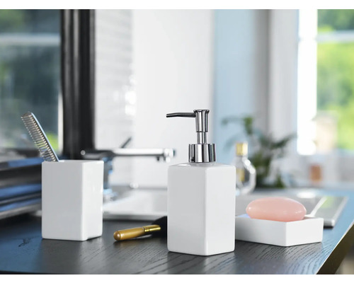 Scène de salle de bains avec distributeur de savon, savon, peigne et pinceau de maquillage sur une étagère