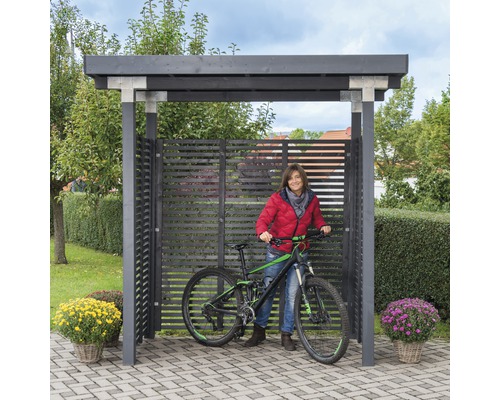 Abri à vélos avec vélo et femme dans le jardin