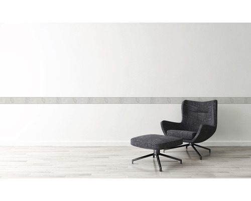 Wand mit floraler Bordüre und Sessel mit Hocker