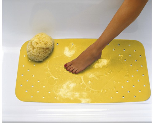 Tapis de bain jaune avec motif d''empreintes de pas et une éponge naturelle dans la baignoire.