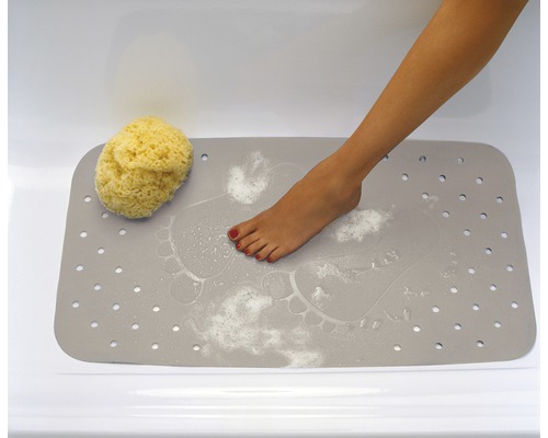 Graue Badewannenmatte mit Fußabdrücken, Badeschwamm und Fuß in der Badewanne