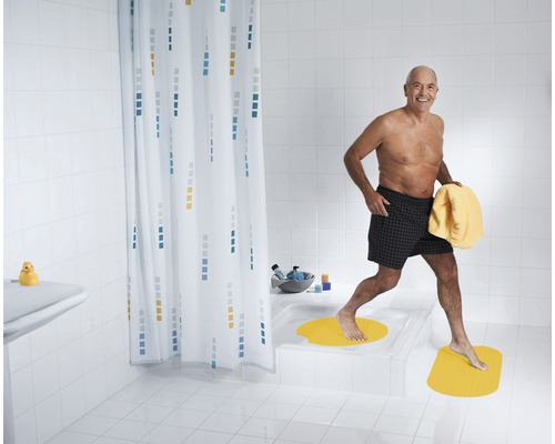 Salle de bains avec baignoire, rideau de douche et tapis de bain pour plus de sécurité