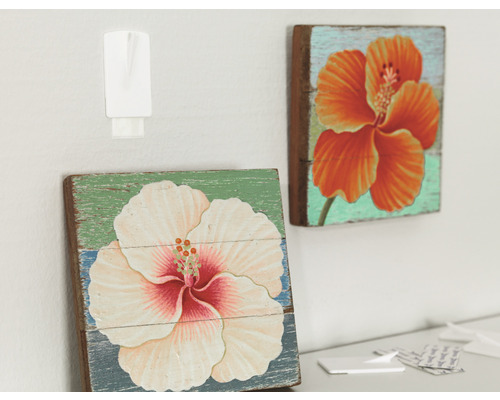 Zwei Holzbilder mit Blumenmotiven, befestigt mit einem Klebehaken.