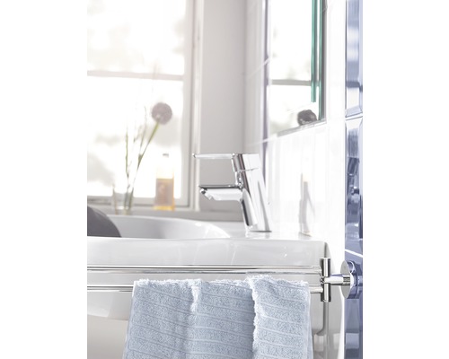 Salle de bain lumineuse avec lavabo, robinet et porte-serviettes