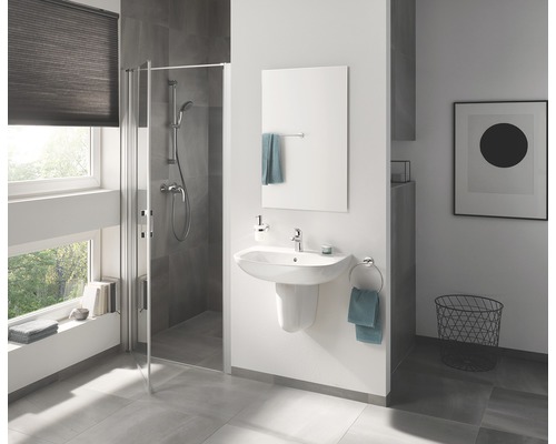 Badezimmer mit Duschkabine, Waschbecken, Spiegel und Accessoires für ein helles und modernes Ambiente