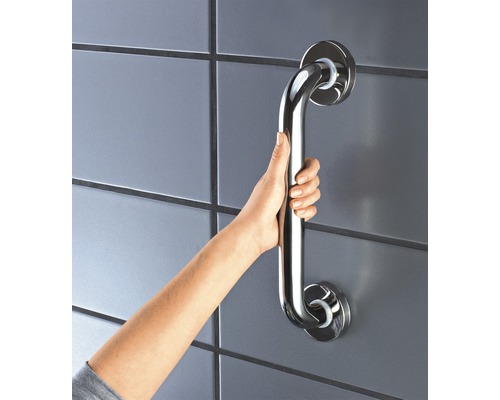 Une main tient une barre d''appui en acier inoxydable sur un mur