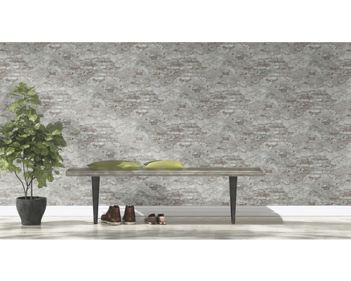 Intérieur décoratif avec banc, coussins, plante en pot et chaussures devant un mur à motif de briques