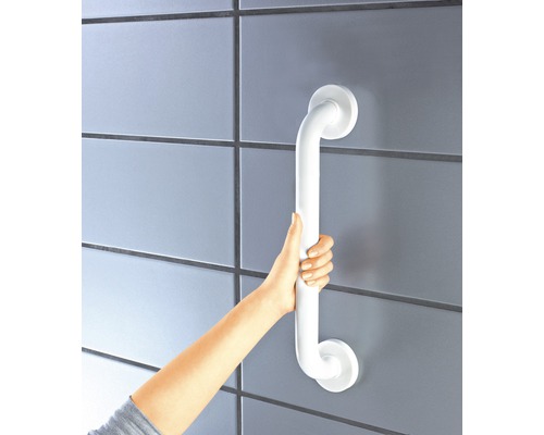 Eine Person hält einen weißen Haltegriff an einer Wand.