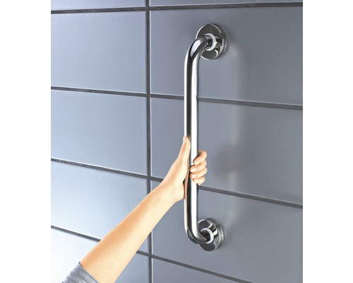 Une personne tient une barre d''appui en métal fixée au mur.