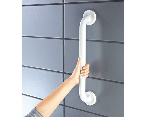 Une personne tient une barre d''appui blanche fixée à un mur carrelé.