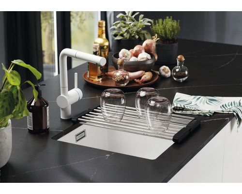 Scène de cuisine avec évier, égouttoir, robinet et divers ustensiles de cuisine