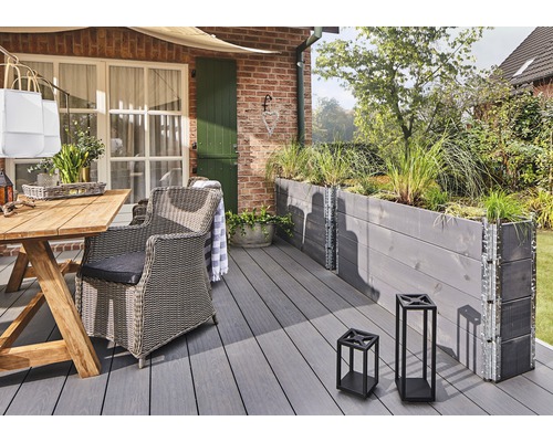Terrasse avec mobilier de jardin en bois, jardinière et lanternes décoratives