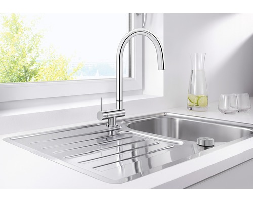 Küchenspüle aus Edelstahl mit Armatur vor einem Fenster