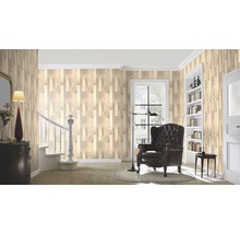 Pièce décorée avec papier peint imitation bois, fauteuil et bibliothèque pour une ambiance chaleureuse.