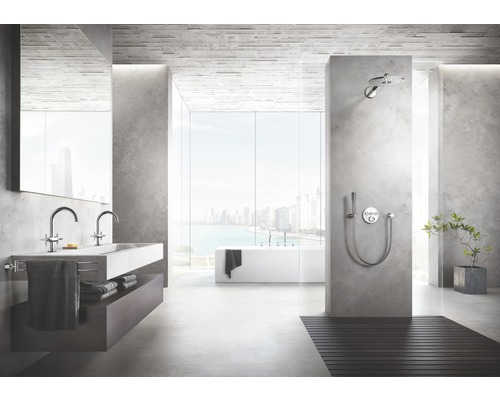 Salle de bains lumineuse avec lavabo, douche, baignoire et grande fenêtre donnant sur une ville