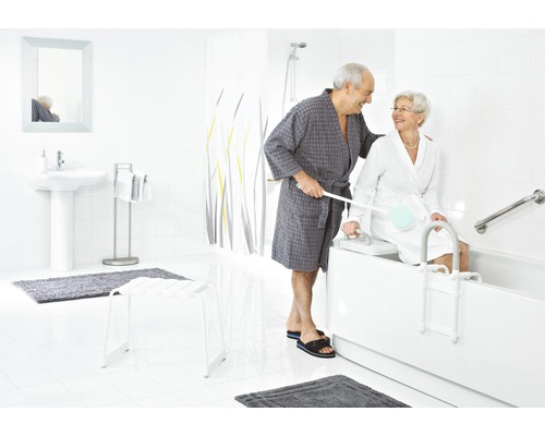 Helles Badezimmer mit Badewanne, Haltegriffen, Badewannenlifter und zwei Personen